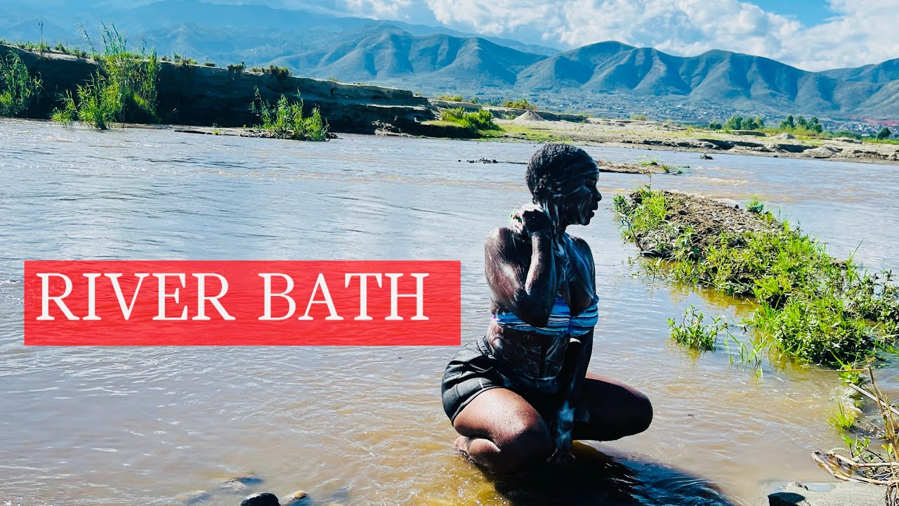 African girl bathing in a village river. Raw & Uncut