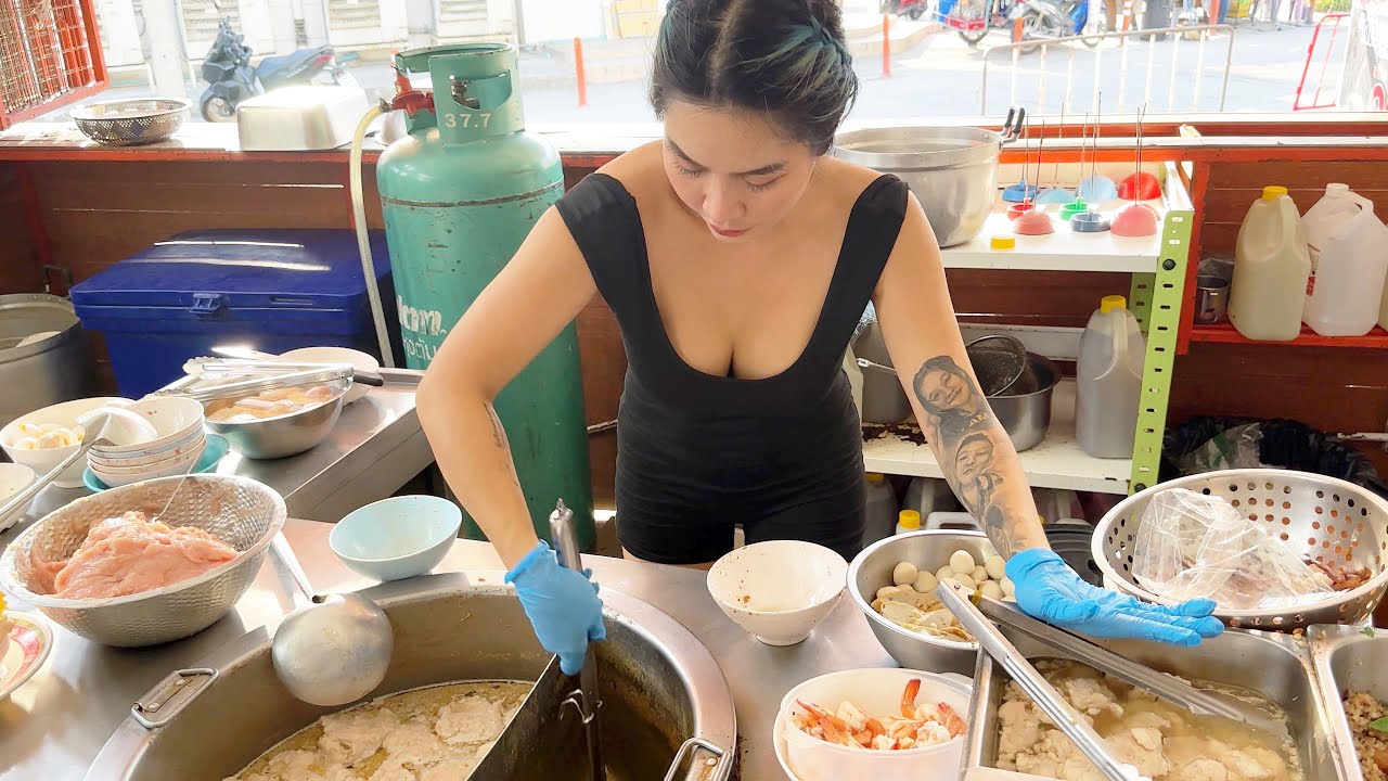 Beautiful lady chef cooking pork noodles - Thai street food