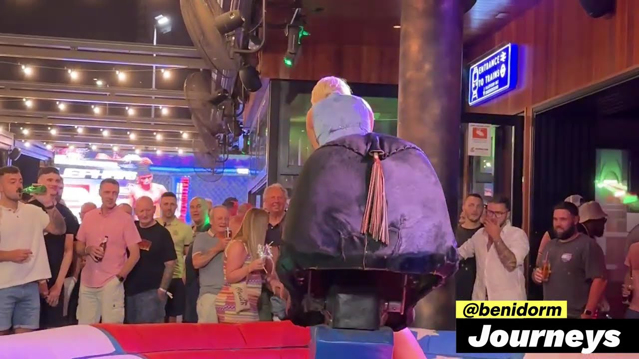Blonde Girl in Denim Dress Riding on a Bull in Benidorm 4K