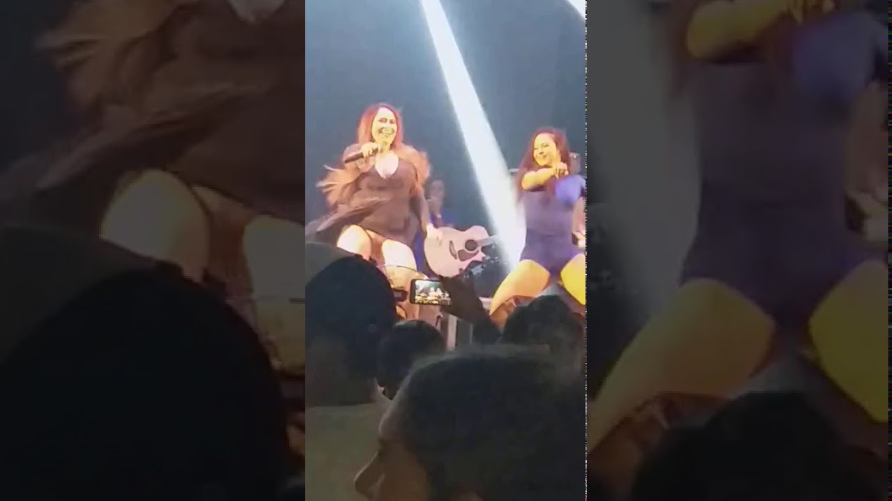 Cantora cantando no palco de vestido e sem calcinha