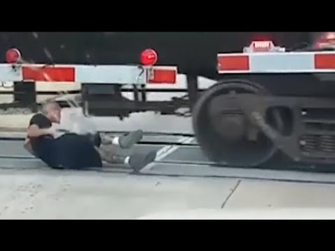 Man rolls under moving freight train