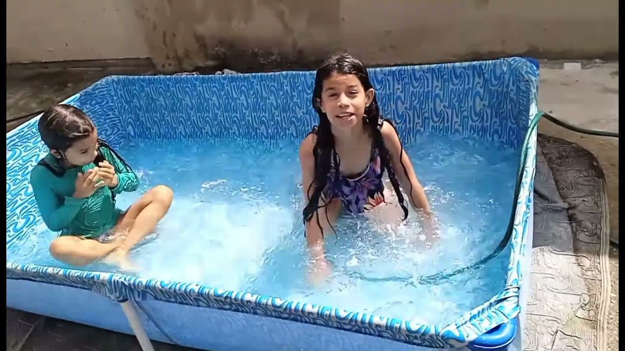 Menina brincando na piscina com a amiga.