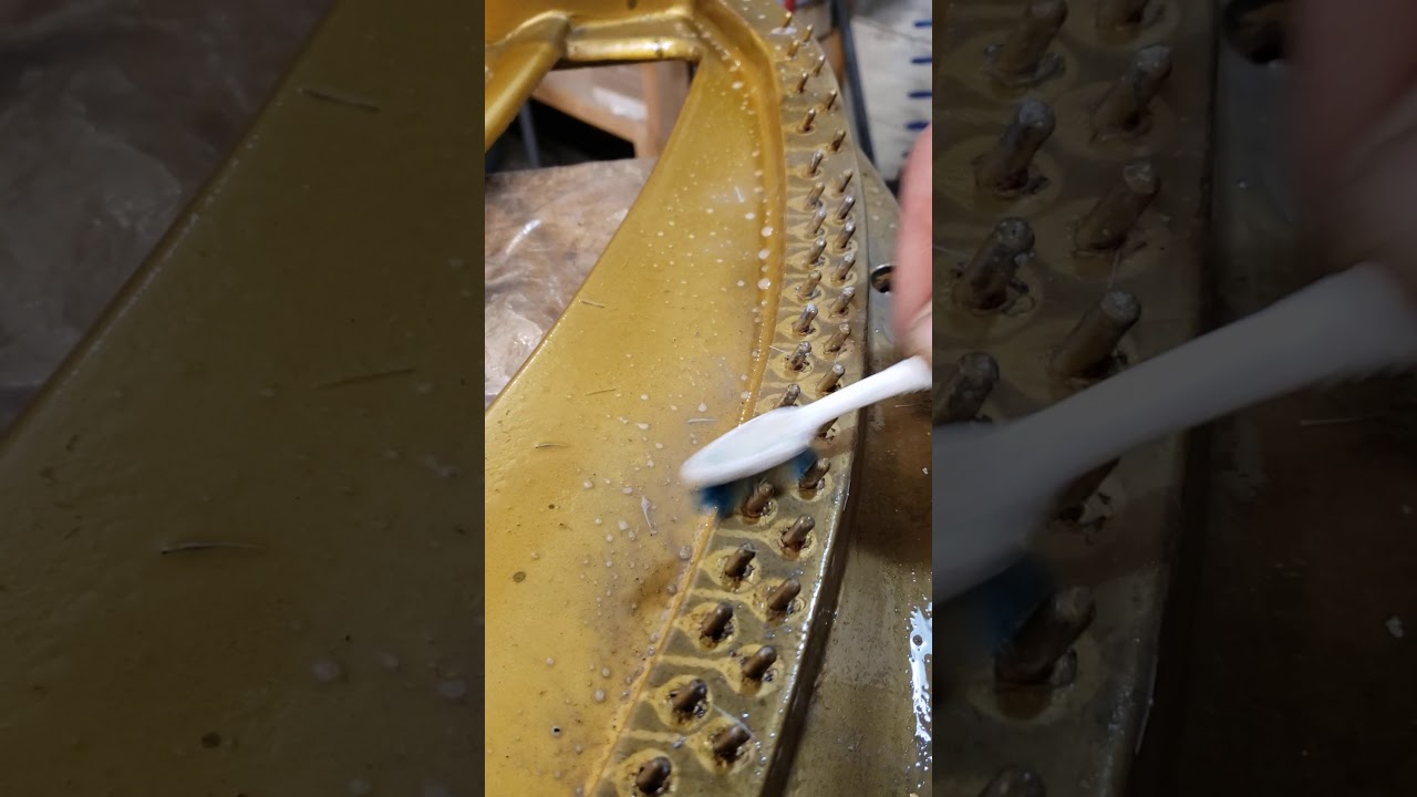 Meticulously cleaning the harp of a Chickering grand manufactured in the