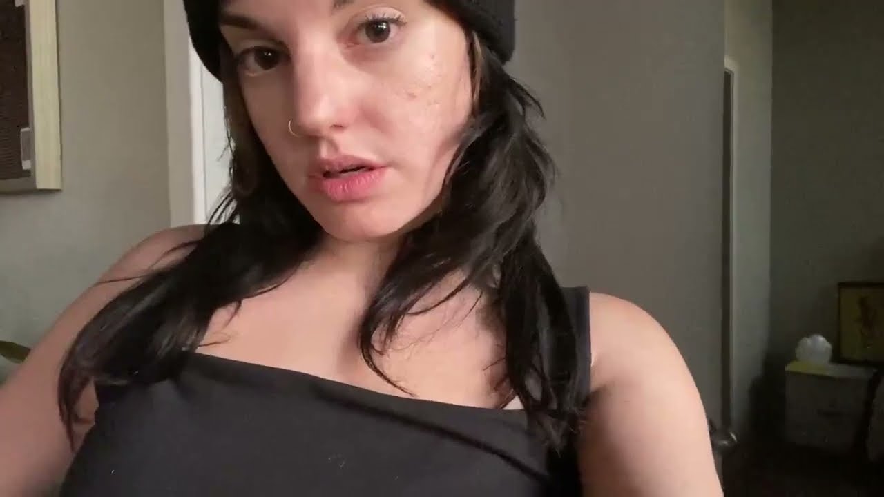 Standing Girl farts in a beanie and black top