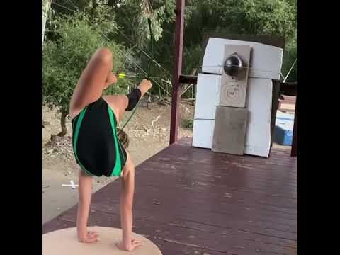 Young Girl Shows Archery Skills With Feet While in Handstand Position - 1140021